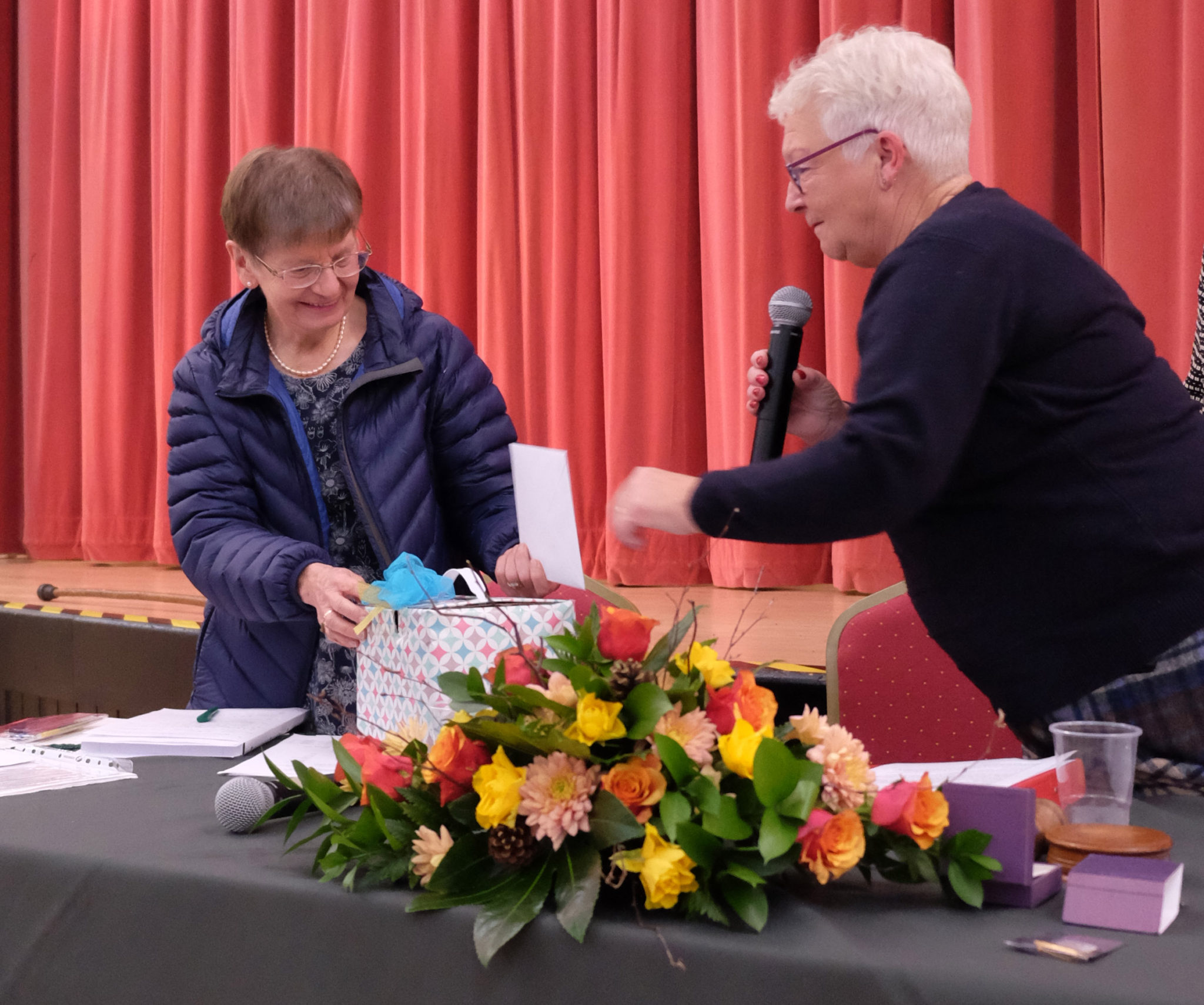 Retiring Area Secretary Jean Hill receives flowers from Area Chairman Sandra Taylor
